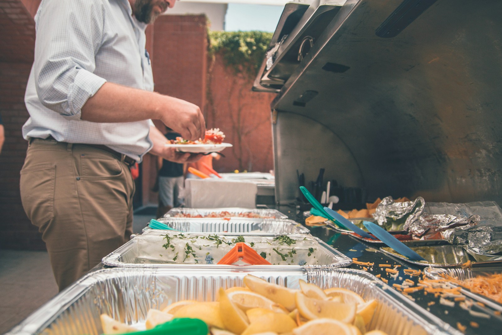 Photo by Kenny Eliason man picking foods on trays